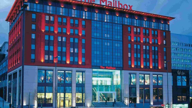 A modern building with a prominent 'The Mailbox' sign. It features large glass windows and a red facade. - Tudors eSuites Birmingham Apartments Jewellery Quarter (Birmingham)