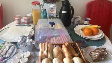 Una tavola imbandita con pane, frutta e bevande.