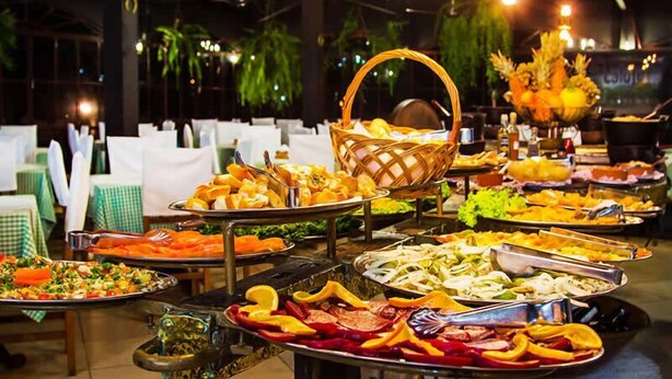 A buffet with various dishes and a decorative centerpiece. - Hotel Fazenda Caluje (Engenheiro Paulo de Frontin)