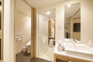 Un bagno d'albergo con il water, un lavandino, uno specchio e un portasciugamani.