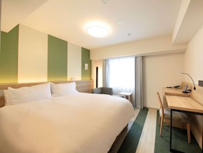 Una camera d'albergo con un letto grande, una scrivania e una sedia.