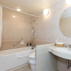 A bathroom with a bathtub, toilet, sink, and a shower with a handheld showerhead. - Hotel Lake View Mito (Mito)