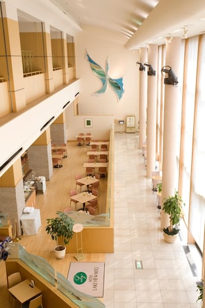 A hotel lobby with a high ceiling, a central mural, multiple seating areas, and a reception desk. - Hotel Lake View Mito (Mito)
