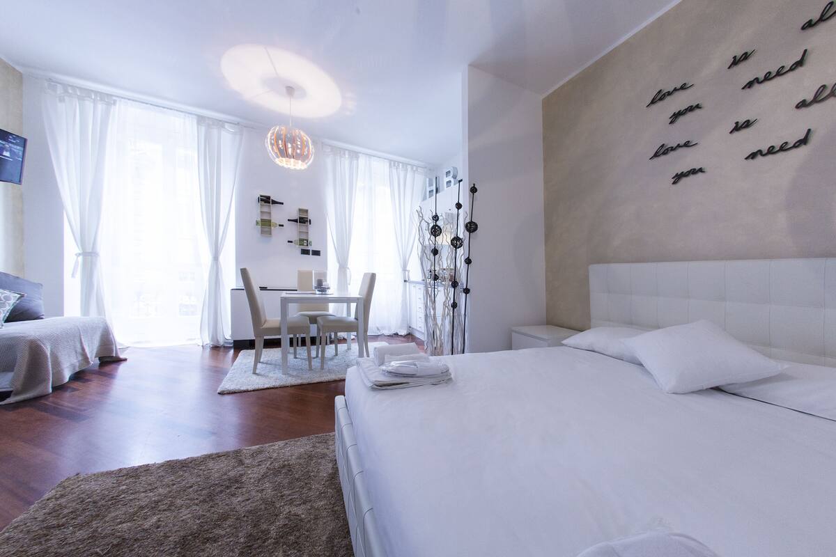 Ein modernes Hotelzimmer mit einem großen Bett, einem Schreibtisch und einem Stuhl.