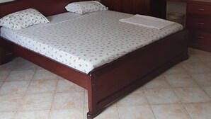 Un dormitorio con cama, armario, ventilador de techo y espejo.
