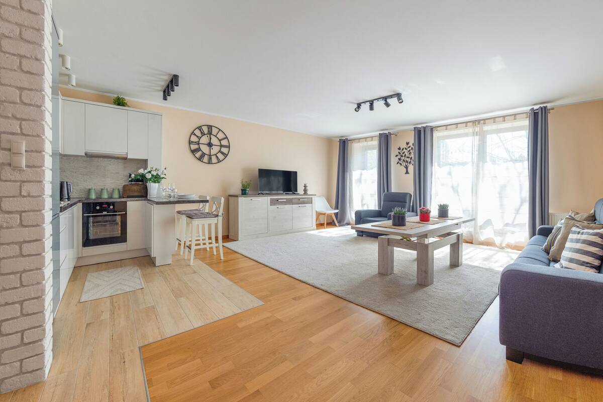 A modern living room with a sofa, coffee table, and a TV in the background.