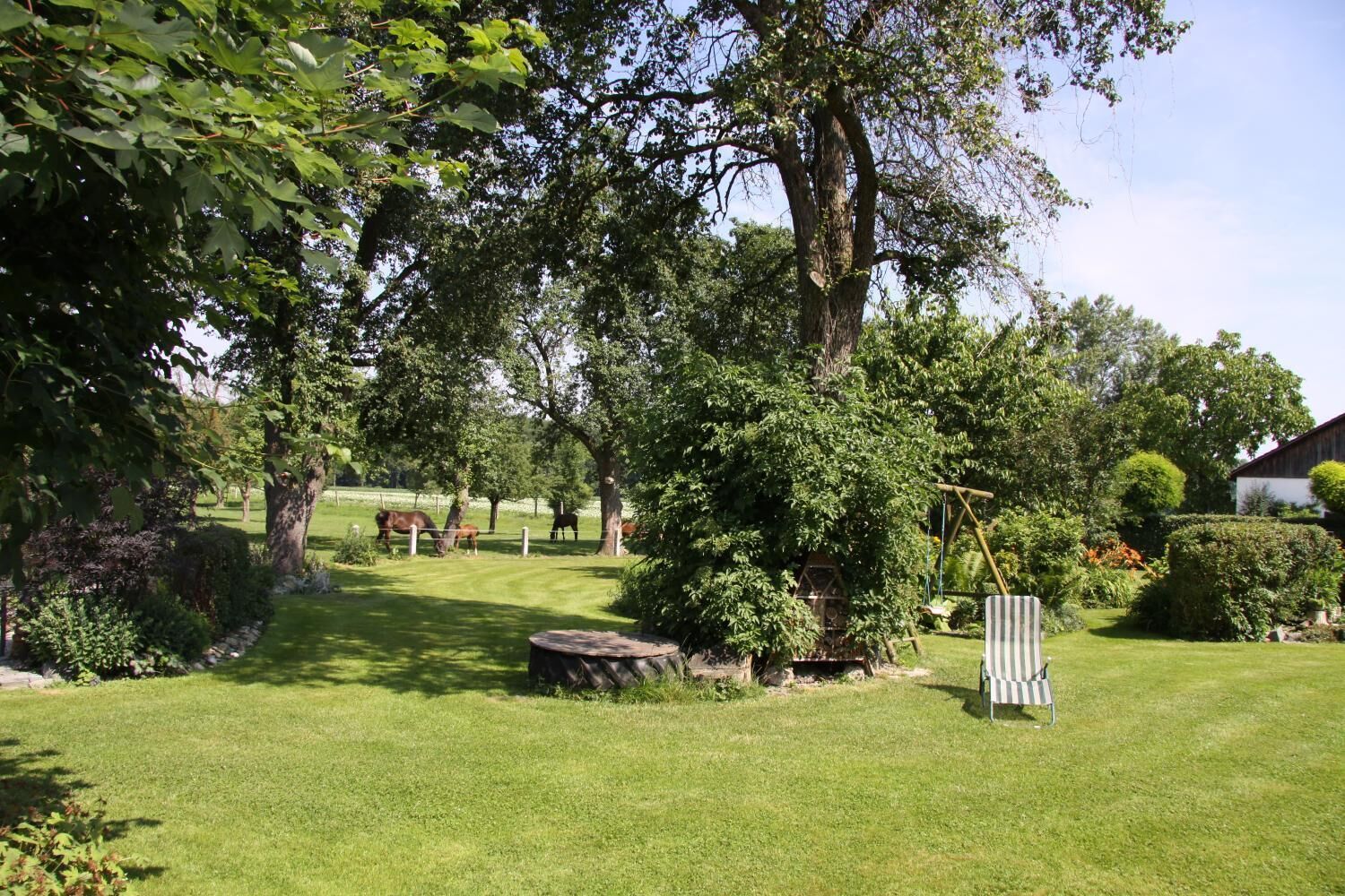 A well-maintained grassy area with trees and a swing set.