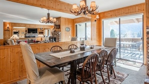 Un intérieur en bois comprenant une table à manger, des chaises et un lustre.