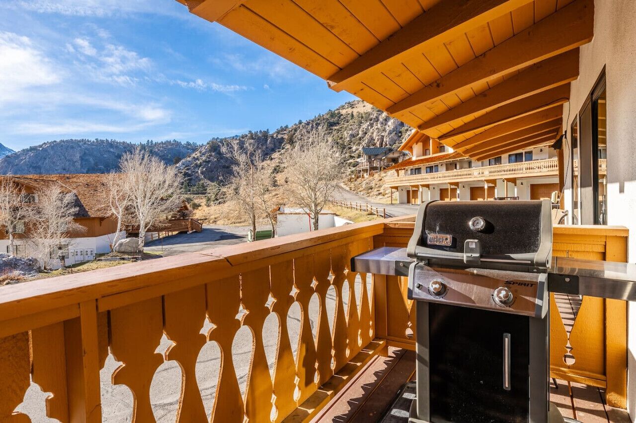 Un balcón con una parrilla, con vistas a un paisaje montañoso.