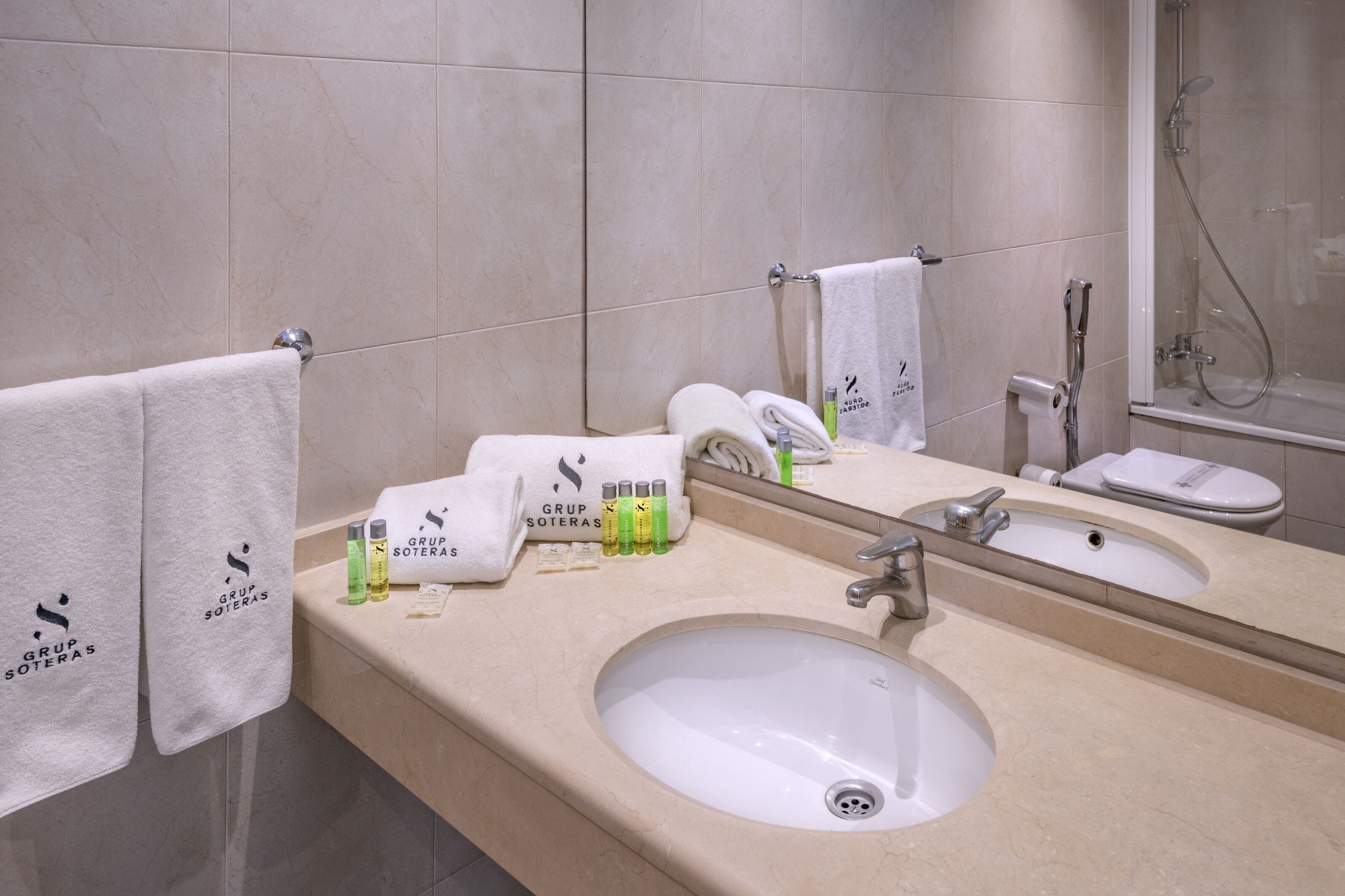 A bathroom with a sink, mirror, and towel rack.