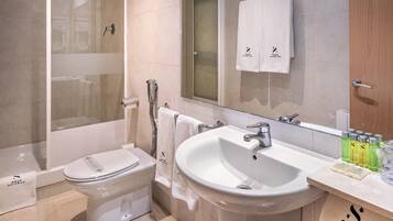 Une salle de bain moderne équipée de toilettes, d’un lavabo et d’une douche.
