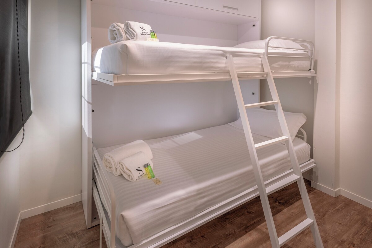 Ein Stockbett mit einer Leiter, einem Handtuch und Toilettenartikeln auf dem oberen Bett.
