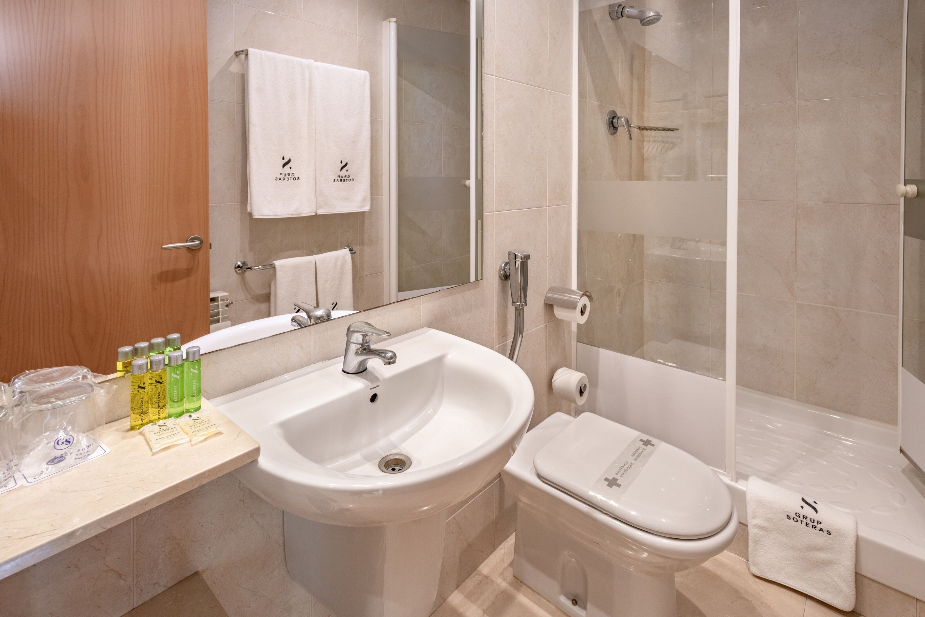 Une salle de bain moderne équipée d’un lavabo, de toilettes et d’une douche.