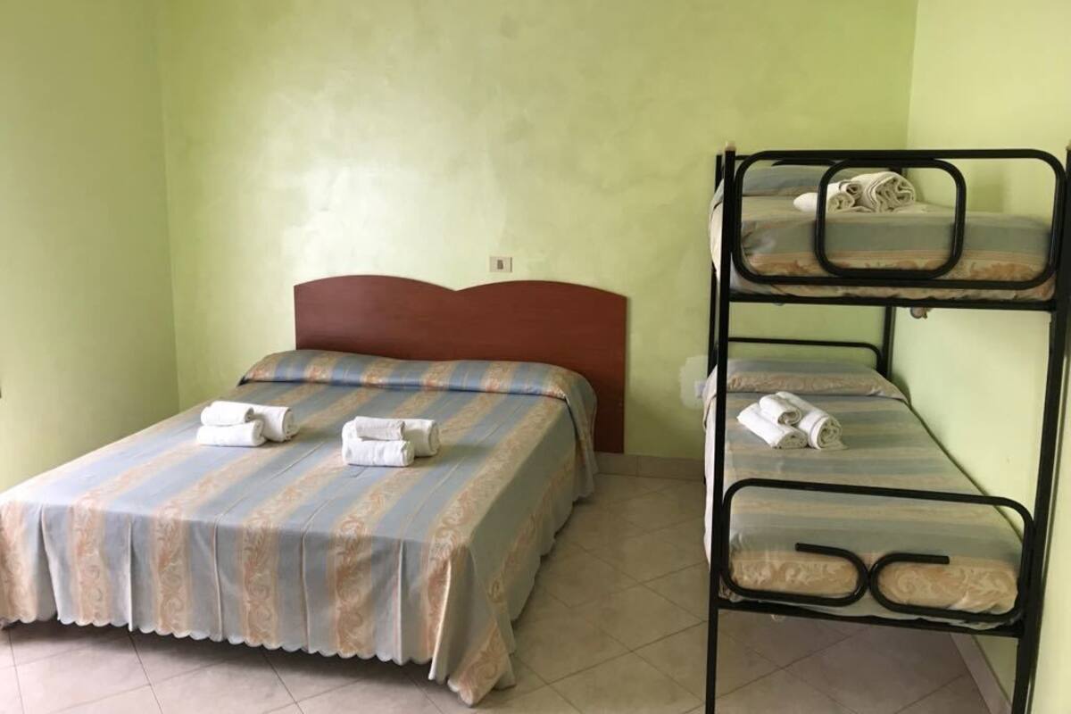 Habitació quàdruple, diversos llits | 1 dormitori, caixa forta a l'habitació i roba de llit 