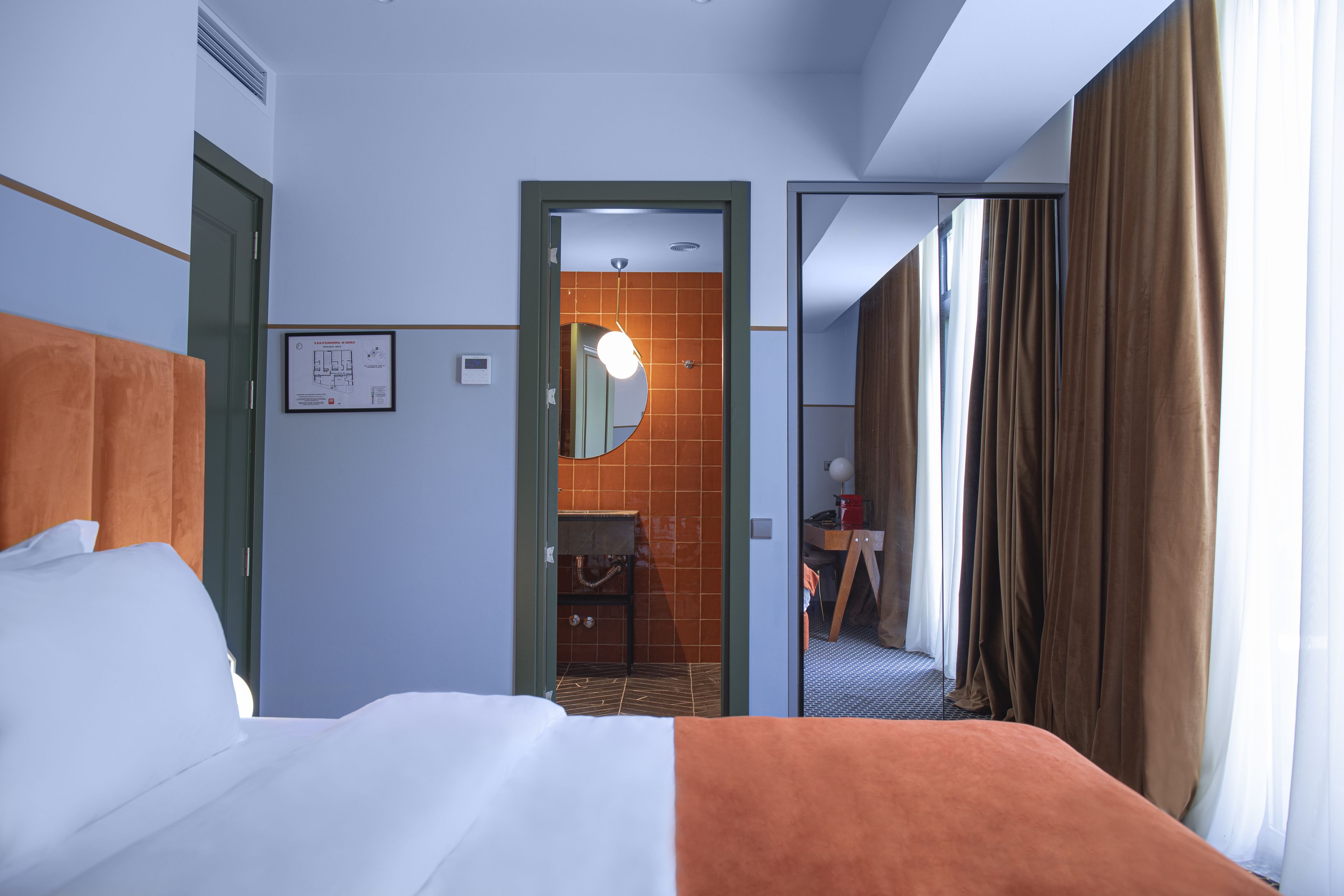 Ein Hotelzimmer mit Bett, Bad und Blick auf den Flur.