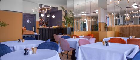 A restaurant with round tables, chairs, and a bar area.