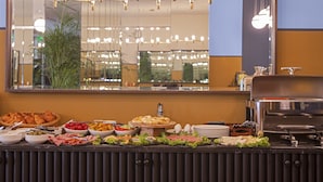 Un bufé con diferentes opciones de comida y una máquina de café.