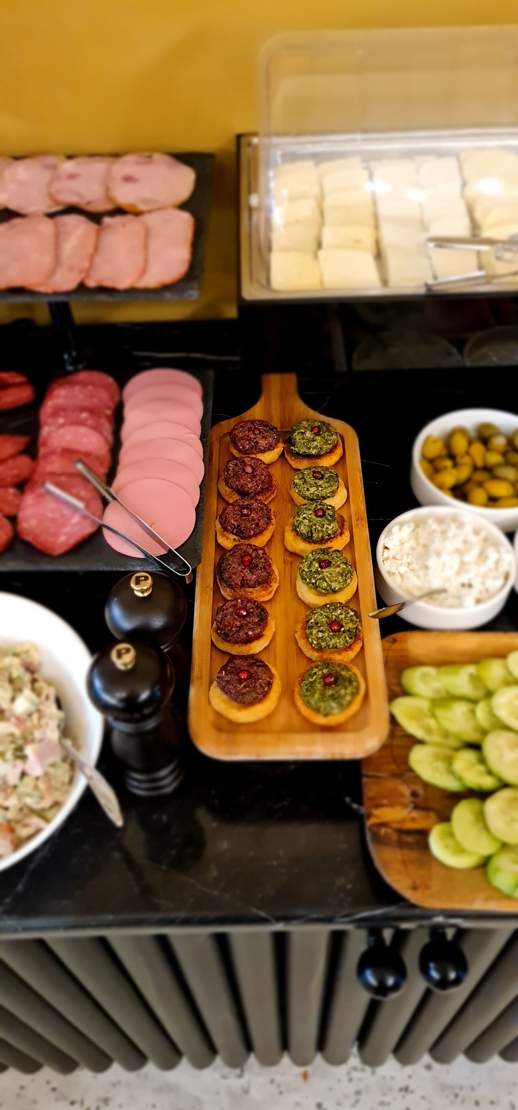 A buffet with various food items including sliced meats, cheese, and appetizers.