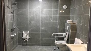 A modern bathroom with a shower, toilet, and sink.