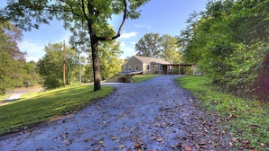A house with a paved driveway, surrounded by trees and a grassy area. - Blessed Mountain Acres w/ Leather Recliners, Hot tub, Swing close to parkway (Sevierville)