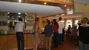 Un espace bar avec un comptoir et des étagères remplies de verres et de bouteilles.