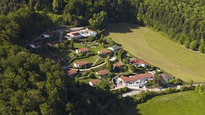 Vue aérienne d’un quartier résidentiel composé de nombreuses maisons, entouré d’une forêt dense.