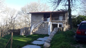 A stone building with a tiled roof, a staircase leading to a balcony, and a sign reading "Casa do Maceiro". - Casa do Mosteiro (Xinzo de Limia)