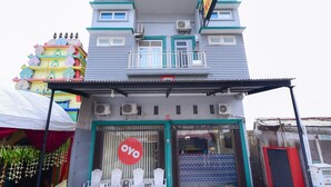 A building with a prominent 'OYO' sign on the facade, featuring a balcony with railings and air conditioning units. - Collection O Banda Aceh near Masjid Raya Baiturrahman formerly Hotel Mulana (Banda Aceh)