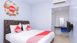 A hotel room with a bed, a desk, and an air conditioning unit. - Collection O Banda Aceh near Masjid Raya Baiturrahman formerly Hotel Mulana (Banda Aceh)