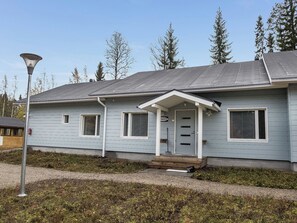A single-story building with a porch, a door, and a window.