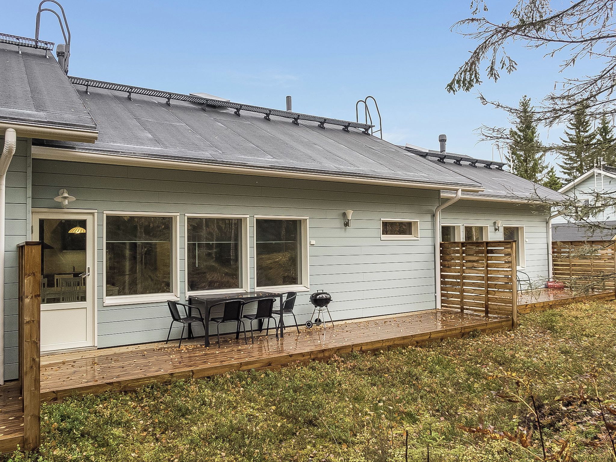 A house with a covered patio, a grill, and a fenced yard.