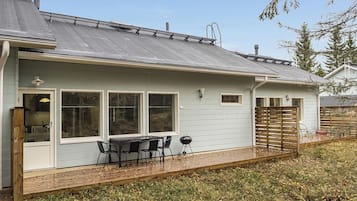 A house with a covered patio, a grill, and a fenced yard.