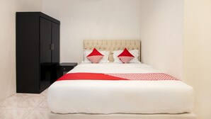 Une chambre à coucher avec un lit, une armoire et une table de chevet.