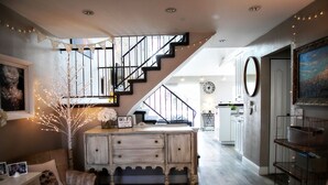 Un interior acogedor con una escalera, un aparador de madera y un comedor.