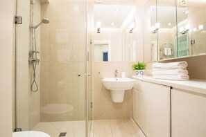 Familie appartement | Badkamer | Een douche, een haardroger, handdoeken, toiletpapier