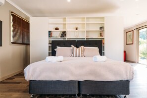 A double bed with a checkered bedspread, a dark headboard, and two pillows.