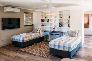 A room with two beds, a desk, a TV, and a bookshelf. - 🌿 Tin Horse Ranch – Private Byron Hinterland Estate | Pool | Sleeps up to 20 (Pearces Creek)