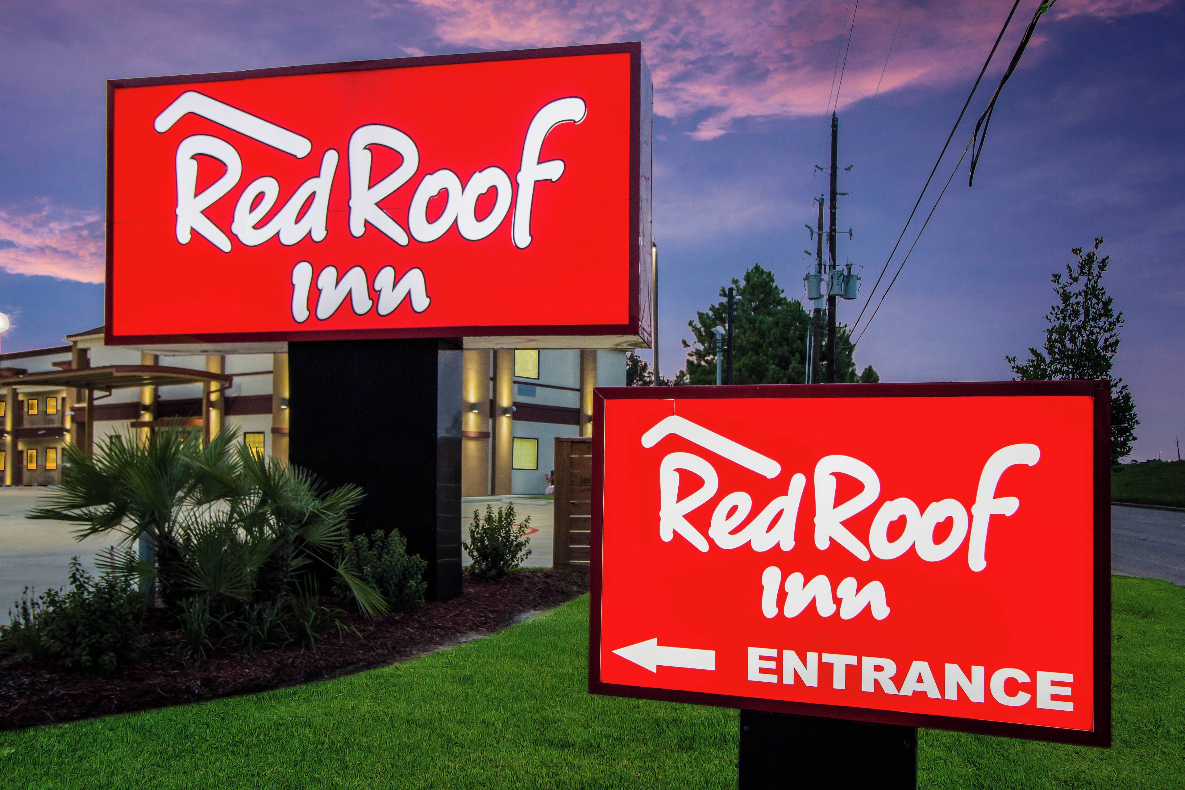 Twee Red Roof Inn borden, één met de hotelsignalisering en de ander ter aanduiding van de ingang.