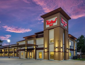 A Red Roof Inn with a modern architectural design, featuring a prominent entrance and a covered parking area. - Red Roof Inn Houston - Willowbrook (Houston)