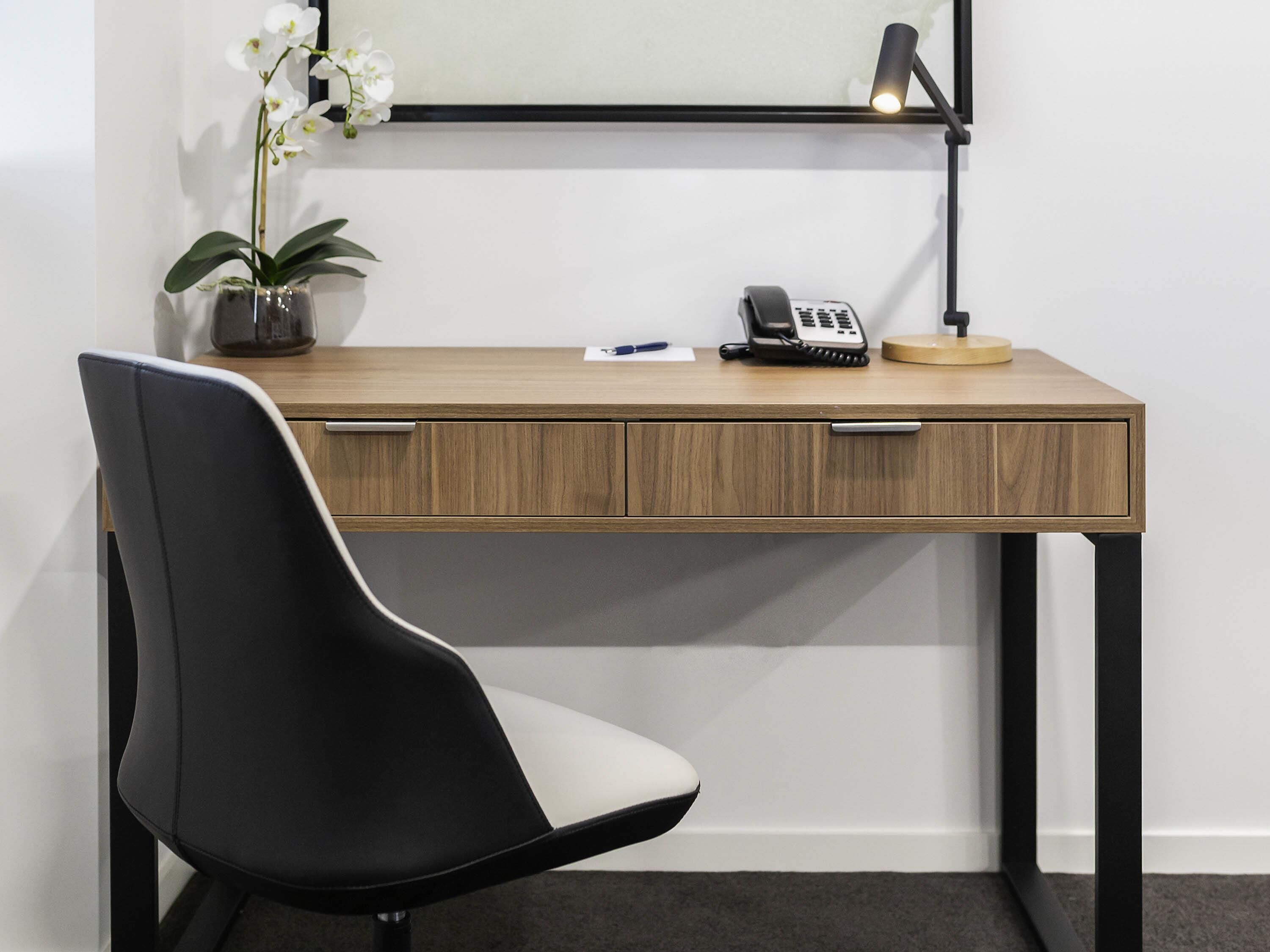 أسرّة بطبقة علوية مريحة وميني بار وخزنة داخل الغرفة ومكتب