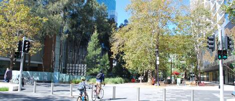 Um cruzamento urbano moderno com faixa de pedestres, semáforos e ciclistas.