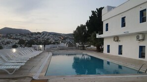 Een buitenzwembad, parasols voor strand/zwembad