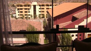 Vista desde una ventana con vistas a un pueblo con edificios y montañas.