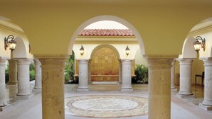 A spacious courtyard with a central fountain, surrounded by columns and arches, and a tiled floor. - Luxury Suites By Estrella del Mar (Mazatlán)
