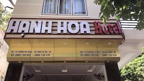 The exterior of Hanh Hoa Hotel with a signboard displaying the name and contact information.
