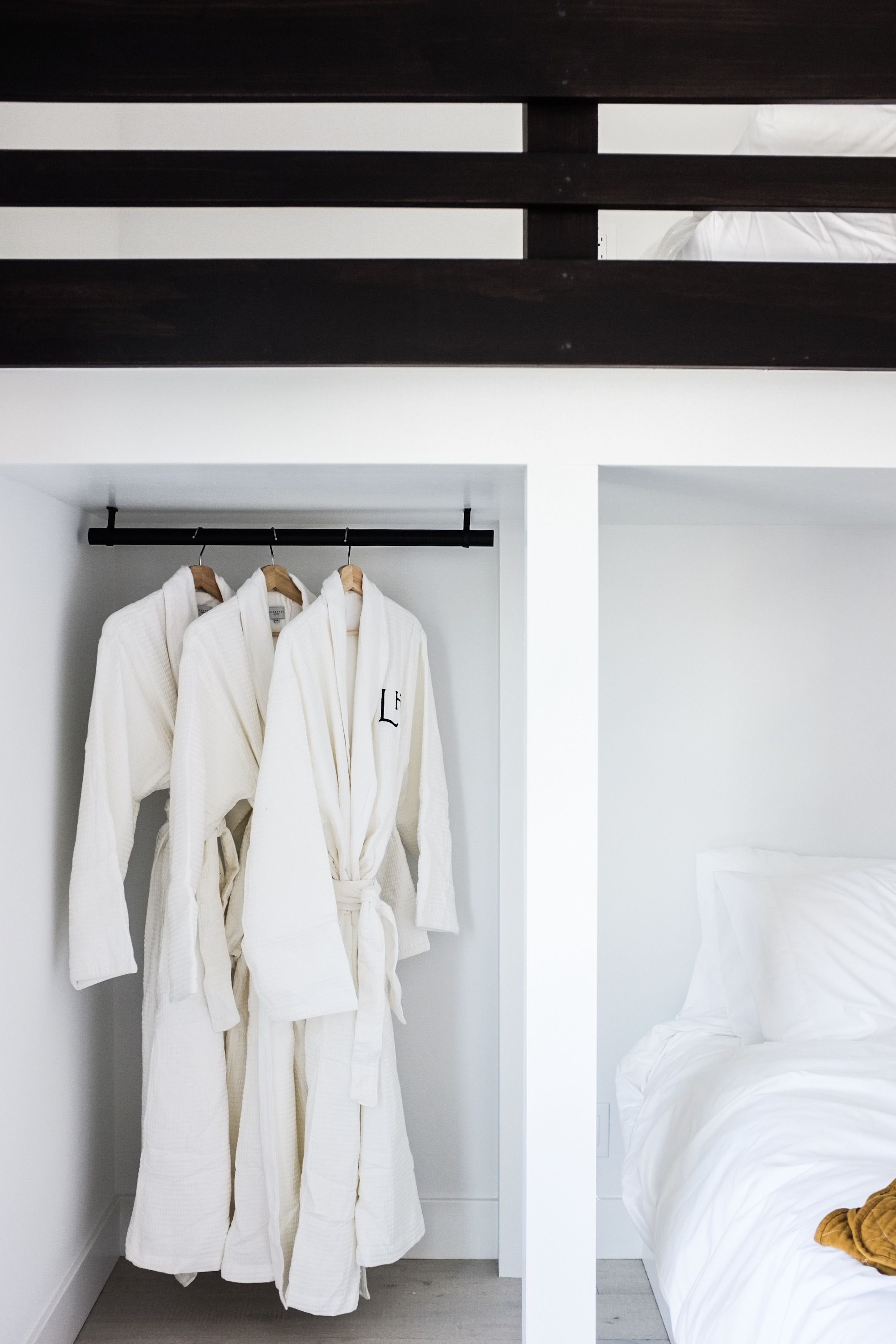 A bedroom with a bed, white bedding, and a wooden headboard.