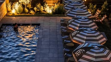 Una piscina al aire libre de temporada, sombrillas