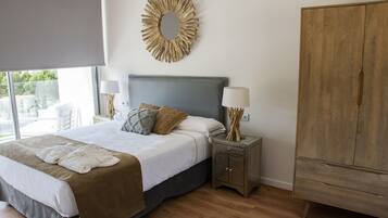 Un dormitorio con cama, mesitas de noche, armario y un espejo decorativo.