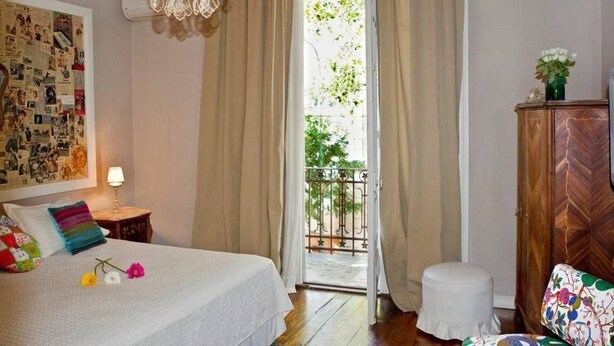 A bedroom with a bed, a nightstand, a dresser, and a window with curtains. - Palermo Living Unique Rooms (Buenos Aires)