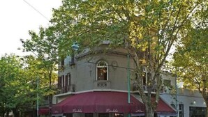 A building with a red awning and a sign that reads "Mandel's." - Palermo Living Unique Rooms (Buenos Aires)